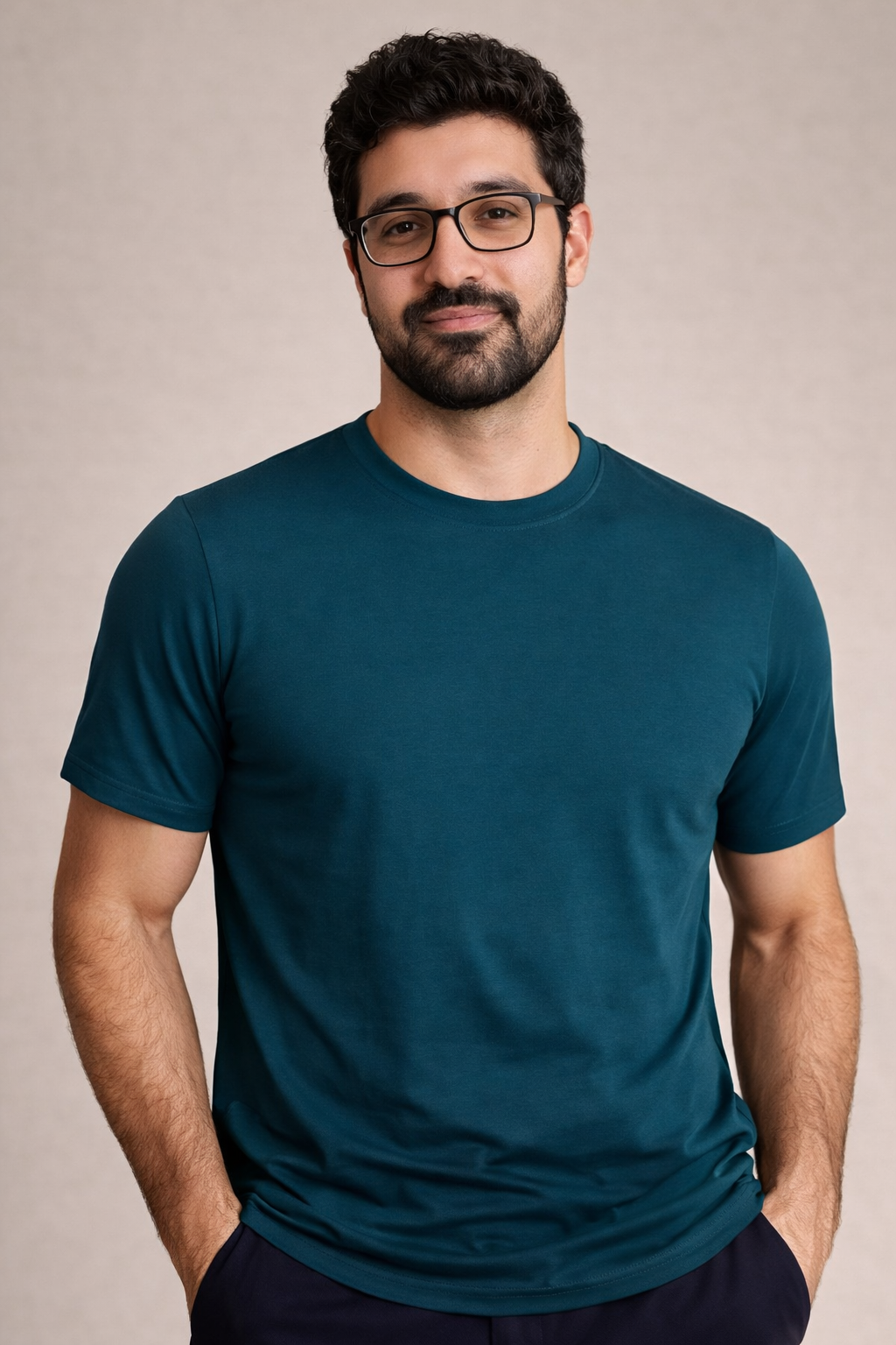 Man wearing a teal t-shirt against a beige background