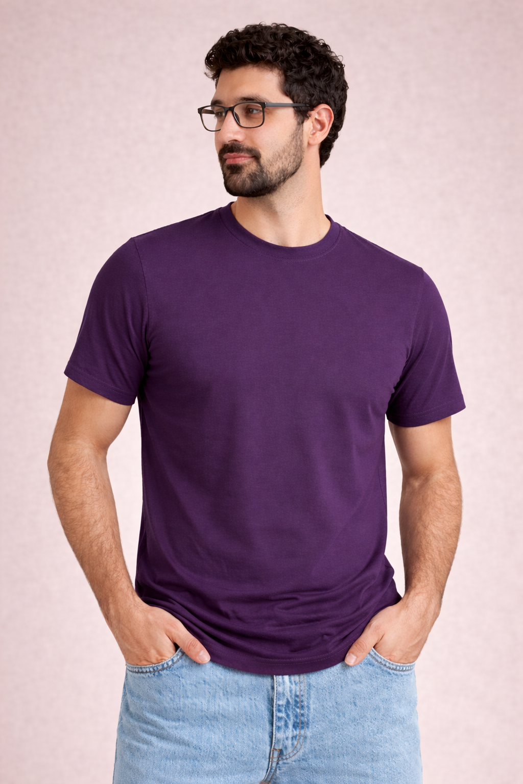 Man wearing a purple t-shirt and glasses against a light pink background