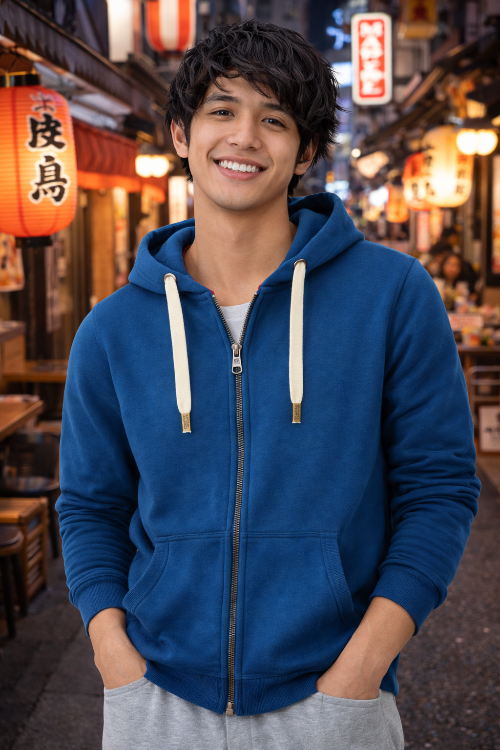 Person wearing a blue hoodie in a vibrant street setting with lanterns and people.