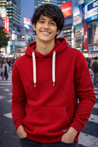 Person wearing a red hoodie in an urban setting with bright lights