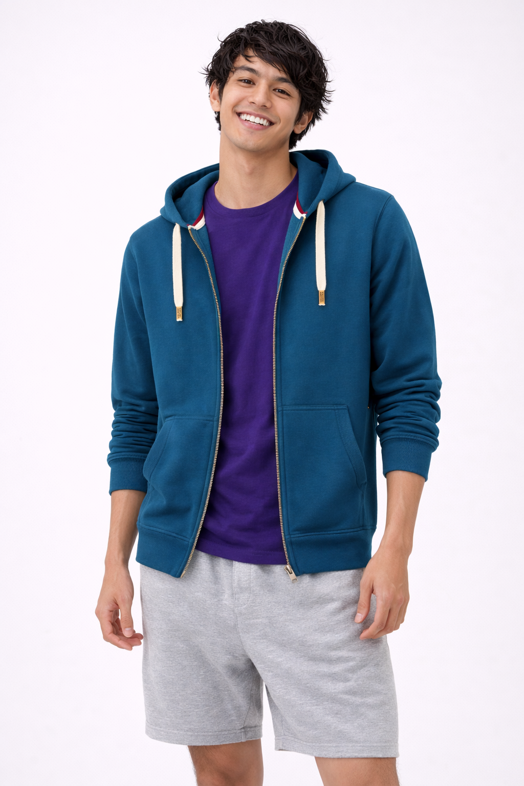 Man wearing a blue hoodie, purple shirt, and gray shorts on a white background