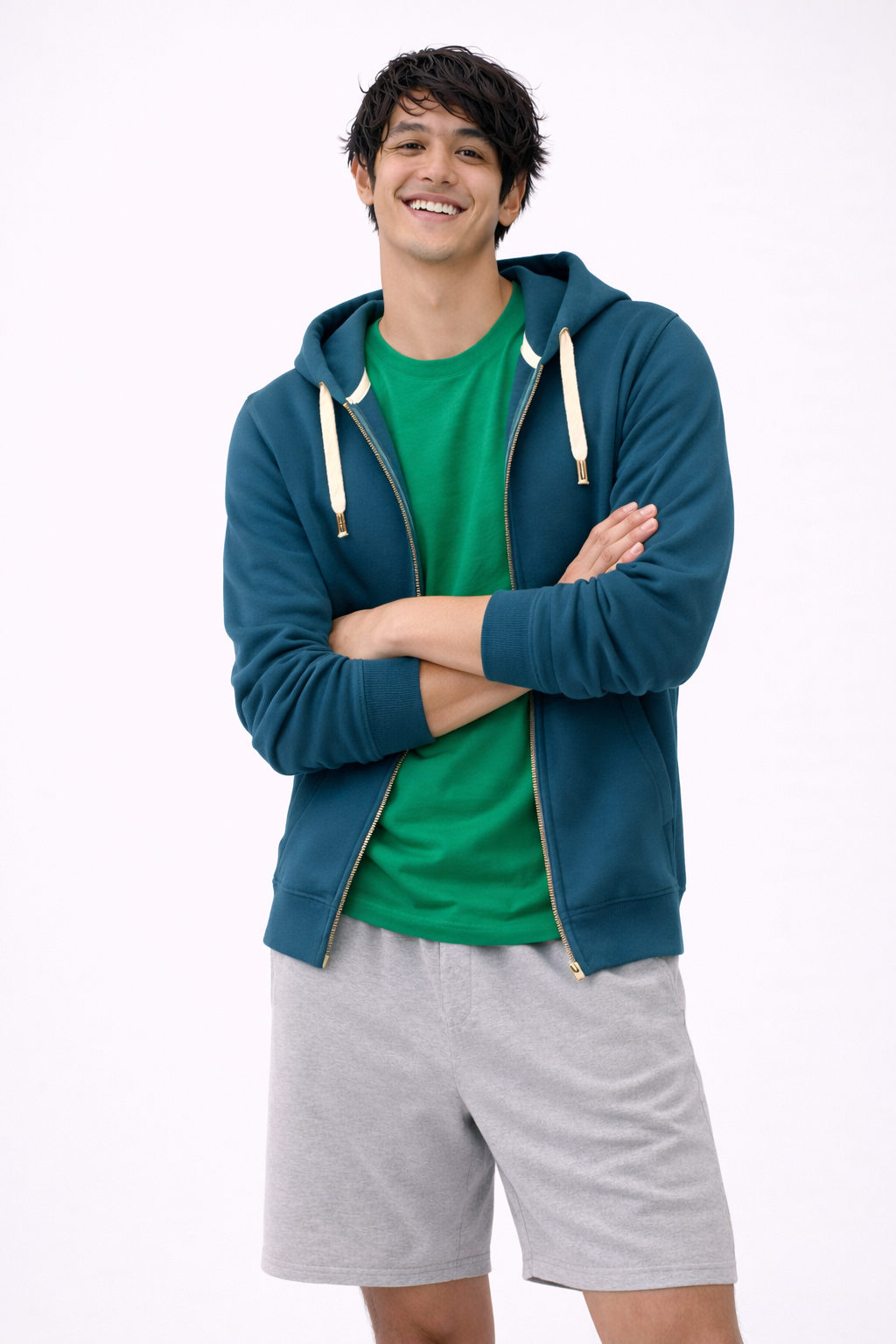 Man wearing a blue hoodie, green shirt, and gray shorts on a white background